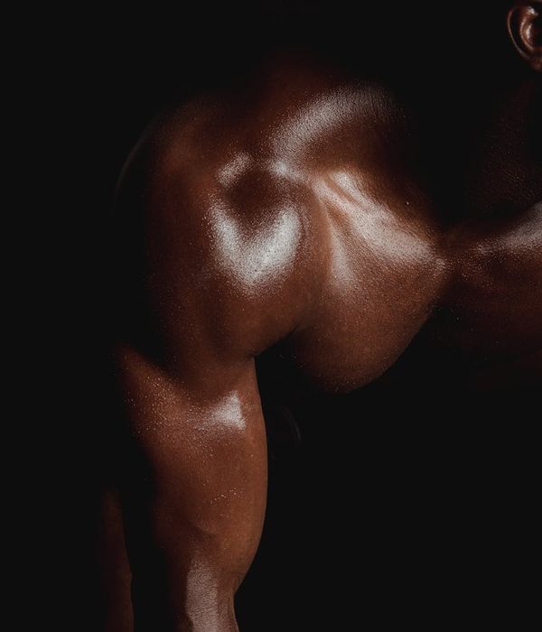Man performing a controlled strength exercise in a modern, dark gym.